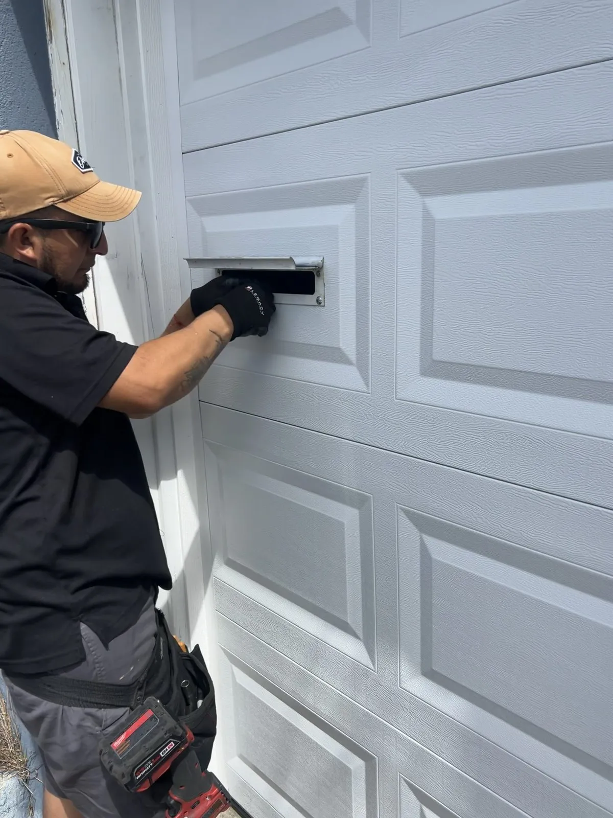 An Island City technician working on a garage door at a customer's home